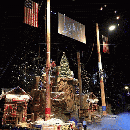 a stage with a christmas tree and a sign that says ' the greatest show in the world '