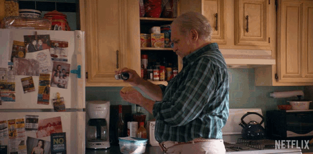 a man standing in a kitchen with a netflix logo on the fridge