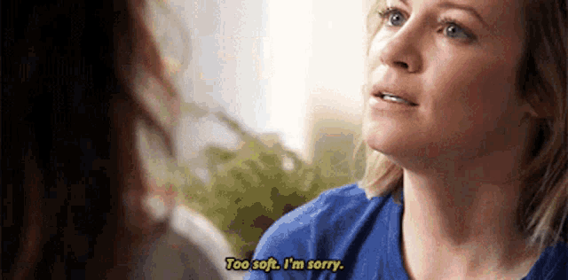a woman in a blue shirt is talking to another woman and saying `` too soft , i 'm sorry '' .