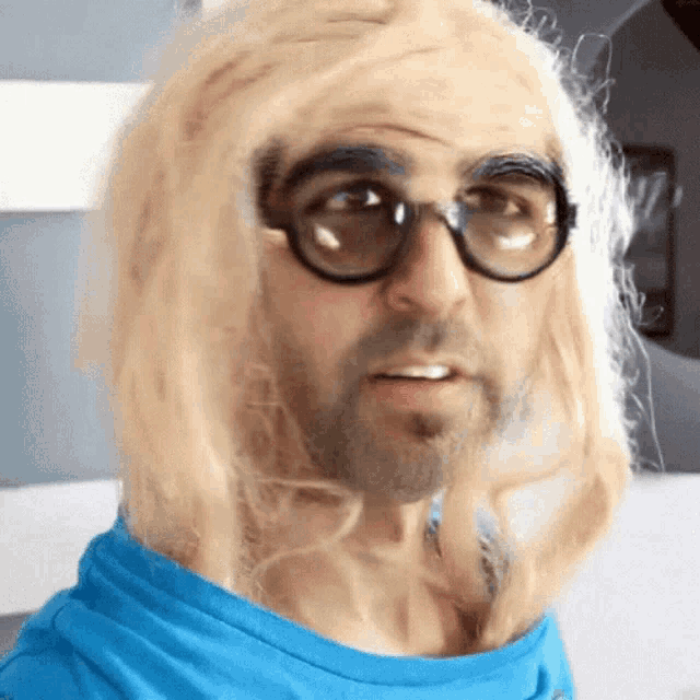 a man wearing glasses and a blonde wig makes a funny face
