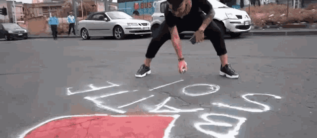 a man is spray painting the word i love on the street