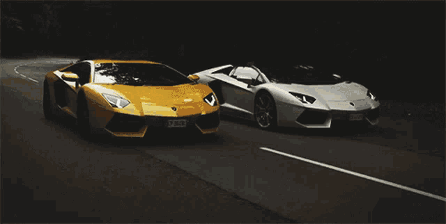two sports cars are driving down a road and one has a license plate that starts with the letter y