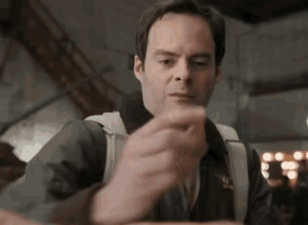 a man is holding a piece of food in his hand in a restaurant .