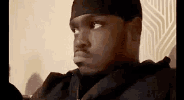 a man wearing a headband is making a funny face while sitting on a couch .