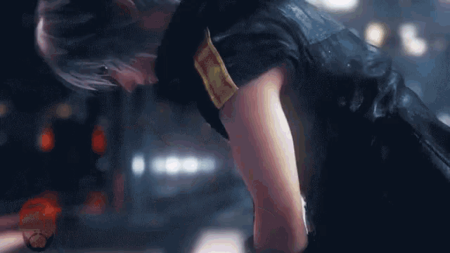 a person in a black vest with a gold collar is kneeling down