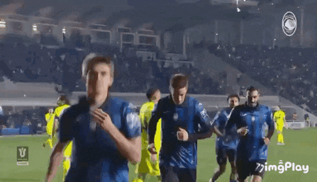 a group of soccer players are standing on a field and talking to each other .