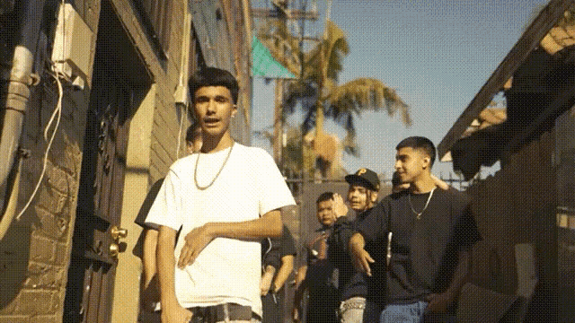 a group of young men are walking down a narrow alleyway