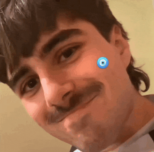 a close up of a man 's face with a blue eye on it