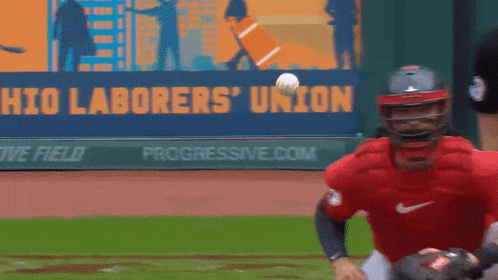 a baseball player is catching a ball in front of a banner that says ohio laborers union