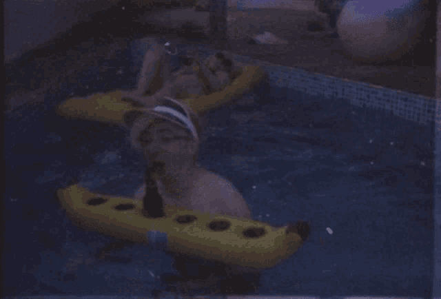 a man in a pool with a banana float
