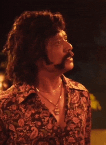 a man with a mustache and a floral shirt says " ennadu " on the bottom