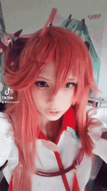a tiktok video of a girl with red hair and a white shirt