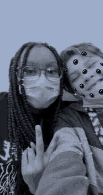 a black and white photo of two people wearing masks and glasses .