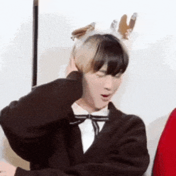 a young man wearing a reindeer headband covering his ears .