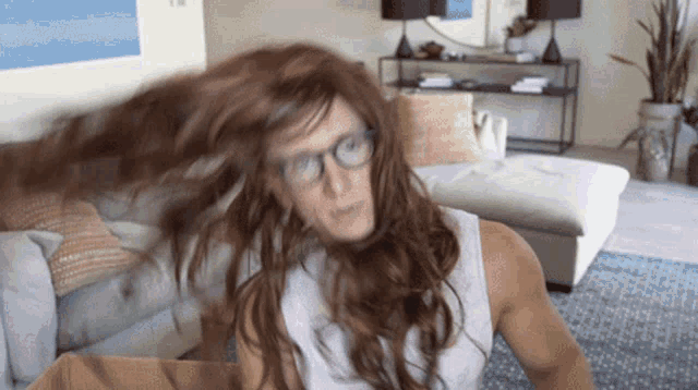 a woman wearing glasses and a wig is sitting in a living room