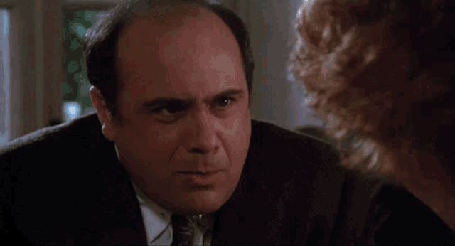 a bald man in a suit and tie is smiling and saying oh ho ho