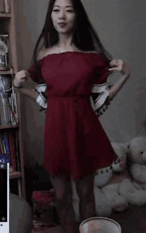 a woman in a red dress is dancing in a room