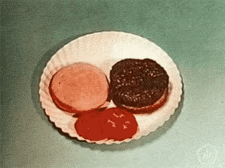 a paper plate with two hamburgers and tomato sauce on it .