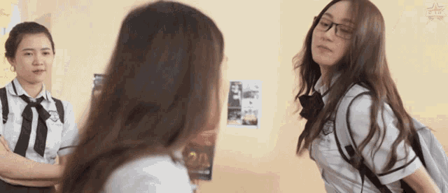 a girl with glasses and a backpack stands next to another girl