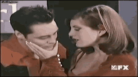a man and a woman are touching each other 's faces and looking at each other .
