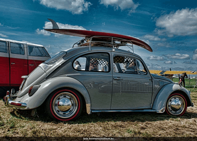 a grey car with a surfboard on top of it