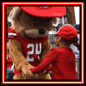 a little girl shakes hands with a mascot wearing a jersey that says 24