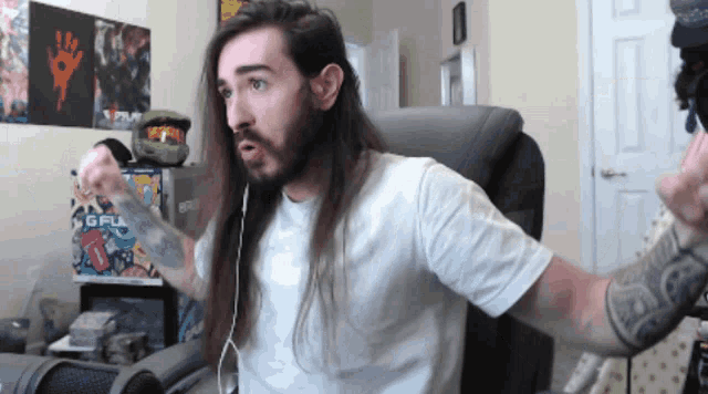 a man with long hair and a beard is wearing a white shirt with the word gfu on it