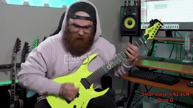 a man is playing a yellow guitar with solar guitars a2.6ln drop d on the bottom