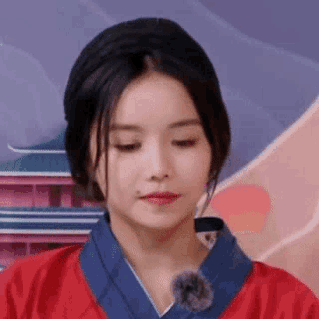 a close up of a woman wearing a red and blue kimono and a hat .