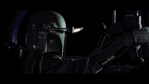 a man in a star wars helmet is holding a gun in a dark room