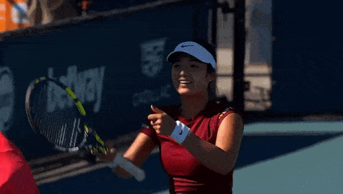 a woman is holding a tennis racquet and smiling .