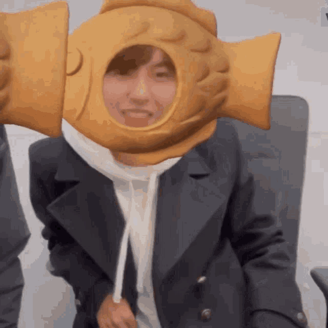 a person wearing a fish shaped hat with a hole in it