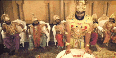 a group of men dressed up in fancy costumes are sitting in chairs