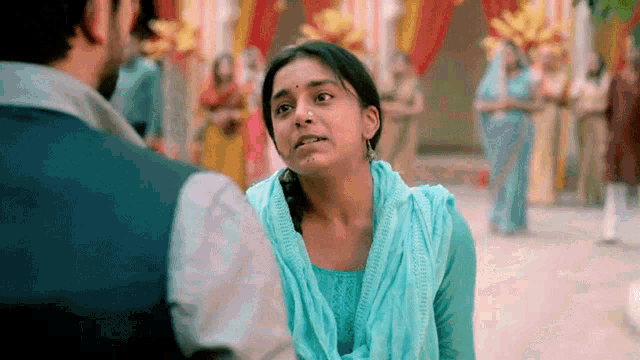 a woman in a blue sweater is looking at a man