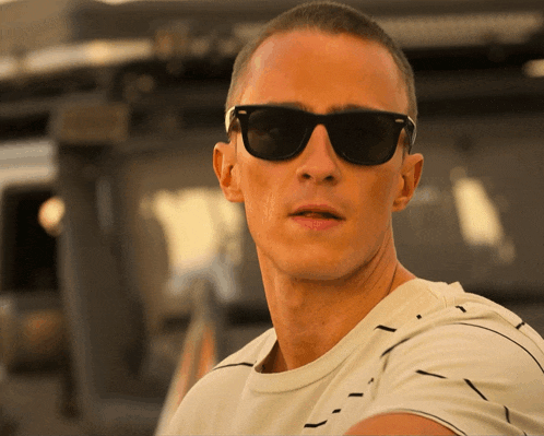 a man wearing sunglasses and a white shirt