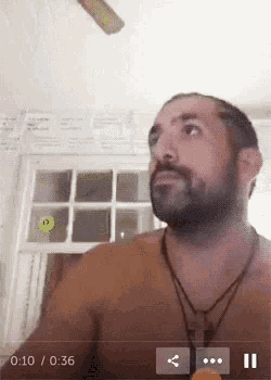 a video of a shirtless man with a beard is being played at 10:36