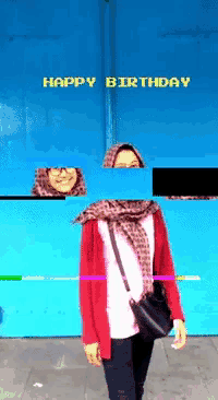 a woman is standing in front of a blue wall with the words happy birthday on it