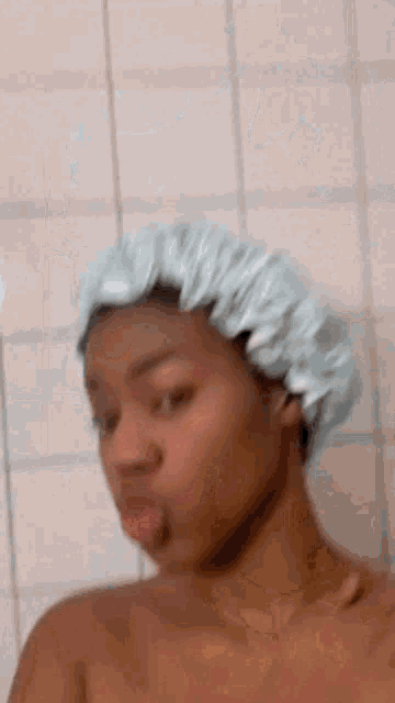 a woman is wearing a shower cap and making a funny face .