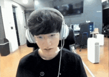 a young man wearing headphones and glasses is looking at the camera