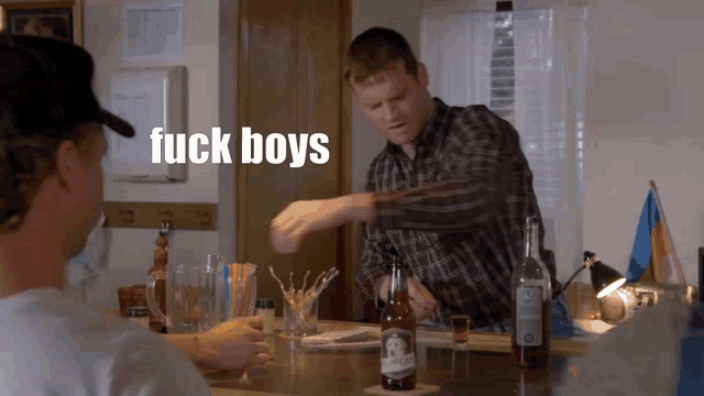 two men sitting at a bar with the words fuck boys on the bottom right