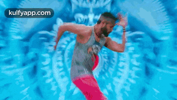 a man in red pants is dancing in front of a blue background .