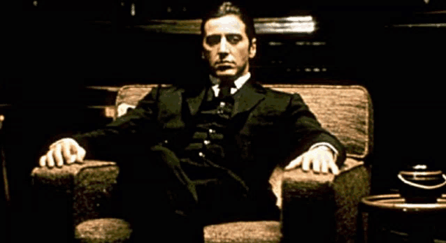 a man in a suit and tie is sitting on a chair
