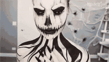 a woman with skeleton makeup on her face and body is standing in a room .