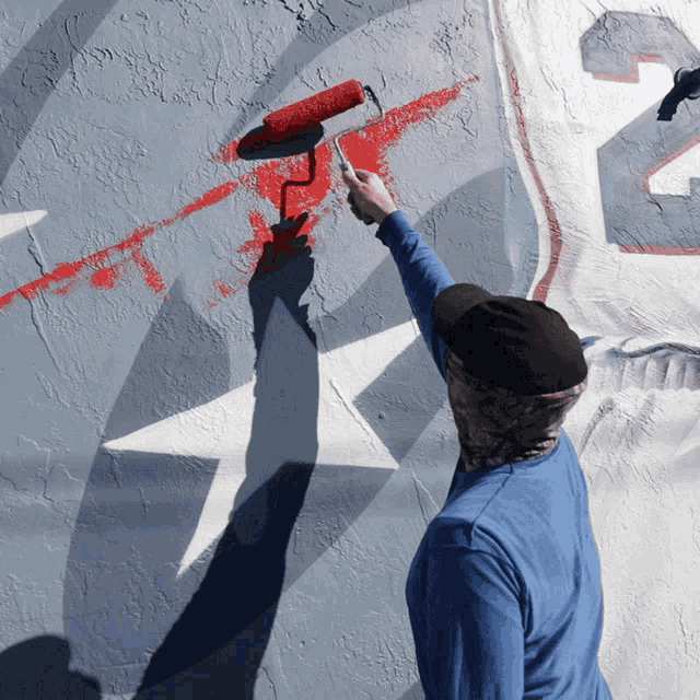 a person paints a wall with a roller and the number 23 on it