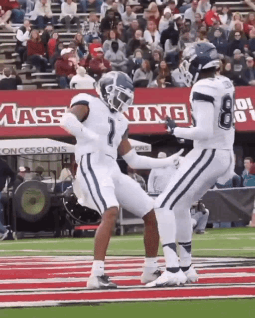 a football player with the number 1 on his jersey kicks another player