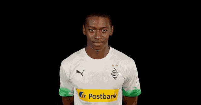 a man wearing a white shirt with the word postbank on the front