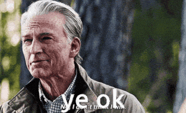 a man with gray hair is standing in front of a tree and says ye ok