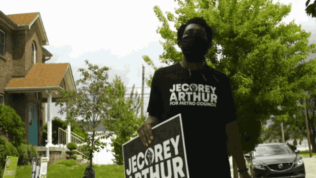 a man wearing a black shirt that says jecorey arthur for metro council