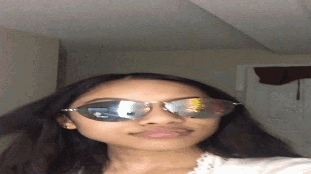 a woman wearing sunglasses with a reflection of a spoon in her eyes