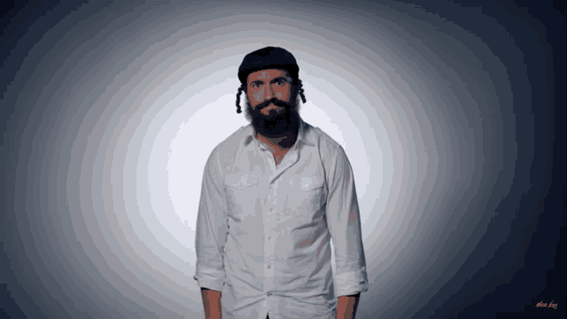 a man with a beard wearing a white shirt and a blue hat